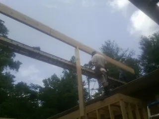 Carpenter setting a ridge beam over a new addition frame — Ice Dam Removal by Roofing Brothers in Roebuck