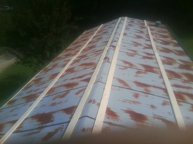 Rusted metal roof panels with new wood purlins before replacement — Storm Damage Roof Repair in Roebuck by Roofing Brothers