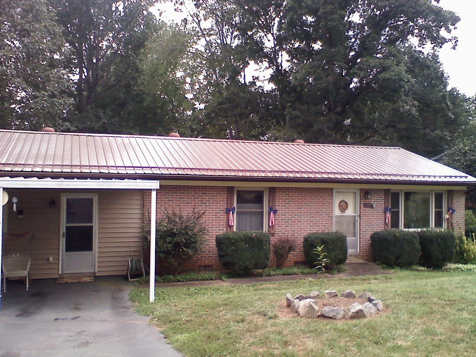 Bronze metal roof and carport on a brick ranch home — Roof Repair work by our crew in Roebuck